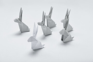 Origami rabbits on light background. Concept of uniqueness