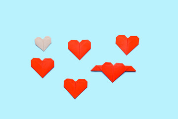 Origami hearts on color background. Concept of uniqueness