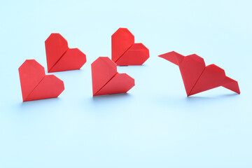 Origami hearts on color background. Concept of uniqueness