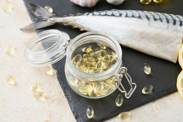 Tasty mackerel and fish oil pills on light background