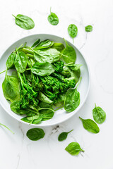 Organic spinach with broccolini (bimi) in bowl on white background