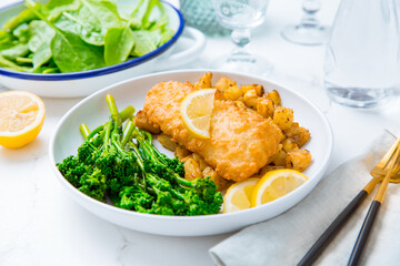 Breaded fisch fillet with spicy baked potatoes and broccoli (bimi) salad