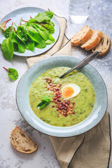 Creamy sorrel soup with egg and bacon bits