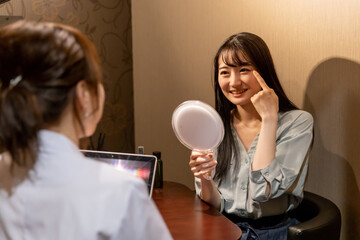 カウンセリングを受ける女性（目元の悩み・笑顔）
