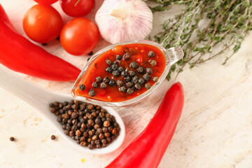Gravy boat with peppercorn sauce and ingredients on light background
