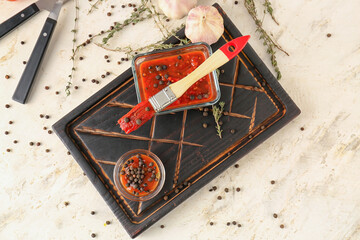 Bowls with peppercorn sauce and brush on light background