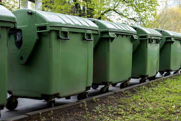 Green dumpsters lined up on the street