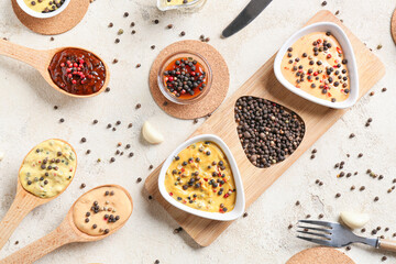 Composition with different sauces and peppercorns on light background