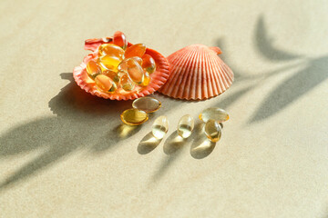 Fototapeta na wymiar Sea shells with fish oil capsules on light background