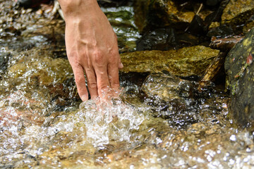 山の湧き水に触れる手