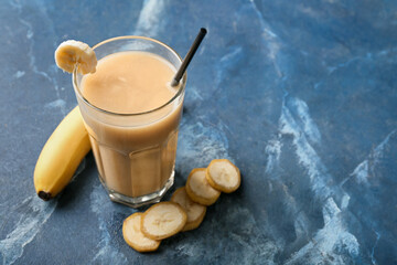 Glass of healthy banana smoothie on color background