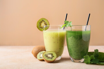 Glasses of healthy smoothie with kiwi and greens on color background