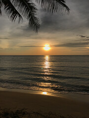 Fototapeta na wymiar The setting sun reflects on the sea at Klong Chaow beach on Ko Kut in Trat, Thailand.