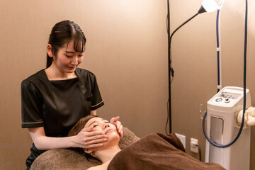 エステサロンで施術を受ける女性（フェイシャルエステ）
