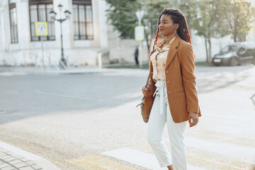 Fototapeta premium Young african american woman crossing the street
