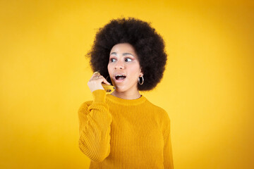 Afro woman talks on the phone with banana