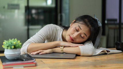 Portrait of female student take a nap while doing assignment in living room - obrazy, fototapety, plakaty