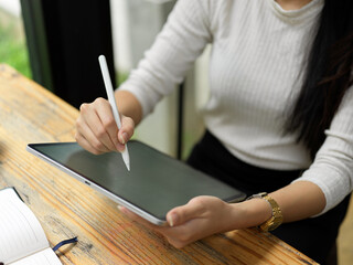Top view of female hand using digital tablet with stylus pen