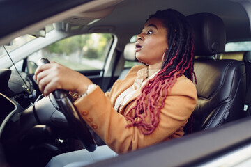 Fototapeta na wymiar Emotional black woman sitting in a car