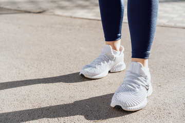 Fototapeta na wymiar Feet of a woman dressed in sportswear and sneakers for running