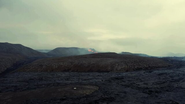 Aerial view over bare hills, towards the basin of the Fagradalsfjall Volcano - orbit, drone shot