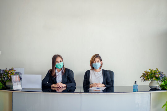 Covid-19 screening concept to students. Two female Asian teachers prepare for coronavirus screening, body temperature, and fever checks for students in the morning before class.