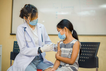 Coronavirus vaccination. Covid-19 vaccine. Doctor giving vaccinations to schoolchildren at School to prevent a serious epidemic among schoolchildren. Little boy getting flu shot. Virus prevention.