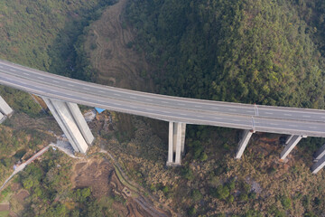 Aerial top view of a curved elevated highway bridge in a valley