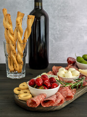 Appetizers board with different italian antipasti, cheese, charcuterie, snacks and wine.