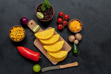 Preparing to cook vegetarian tacos with mushrooms, beans, peppers, corn, and cheese.