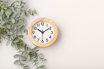 Wood clock with plant decor on beige background