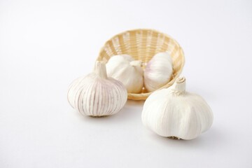garlic on bamboo basket isolated on white background