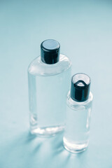 Transparent glass bottle of cosmetic perfume on a blue background. A jar of cosmetics, eco-friendly cosmetics.