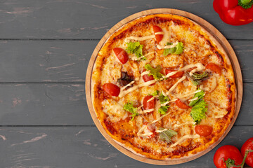 Delicious pizza on gray wooden background top view