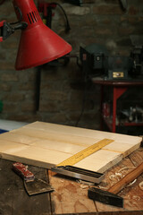 Workshop with tools on the wooden table and red lamp	