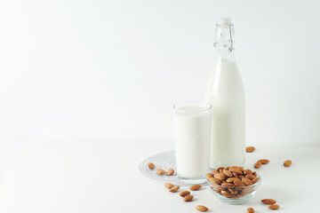 A glass with almond milk and the bowl with almonds