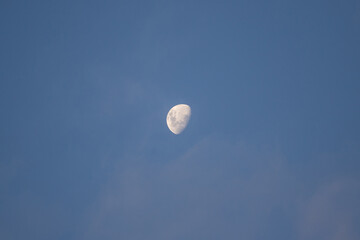 Waning gibbous moon on blue sky.
