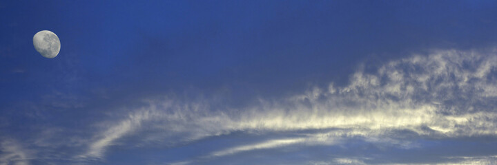 Obraz premium Magnificent white Altostratus cloud in a blue sky with a waning moon. Australia.