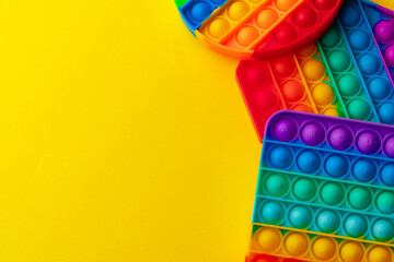 Colorful antistress pop it toy on yellow background