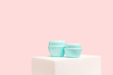 Cosmetic cream jars on podium against a pink background. Spa and skin care concept. Presentation product concept. Mock up