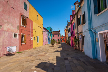 Fototapeta na wymiar Old and small beautiful multi colored houses (bright colors) in Burano island in a sunny spring day. Venetian lagoon, Venice, UNESCO world heritage site, Veneto, Italy, southern Europe.