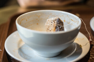 Top view of an empty dirty mug after tea. A dirty mug with a used tea bag. Dirty dishes.