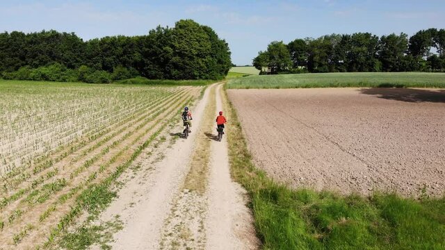 Zwei Radfahrer auf einem Feldweg entdecken einen Hasen