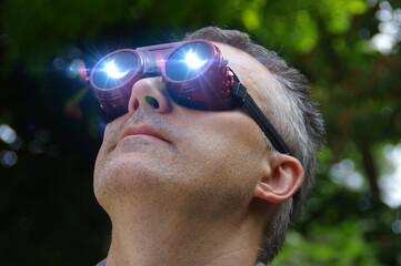 Man watching a solar eclipse phenomenon through safety glasses