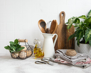 Kitchen utensils, tools and dishware on on the background white tile wall.