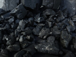 Dark coal texture, the remnants of wood burning into charcoal that can be used for barbecue