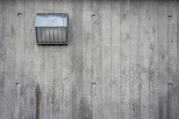 Grungy concrete textured wall with grey steel light fixture