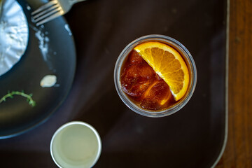 Top view ice orange Americano coffee on table.