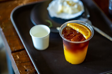 Top view ice orange Americano coffee on table.