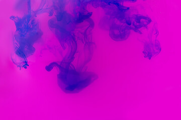 Beautiful ink mix macro. Pink, purple, blue, violet colors watercolor pouring. Paint movement macro. Fluid art painting. Moving flowing stream of liquid paint. Decorative abstract background.
